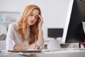 Woman experiencing a stress headache | Healthier Me Today