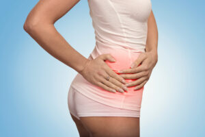 Young female touching her right side in pain colored in red | Healthier Me Today