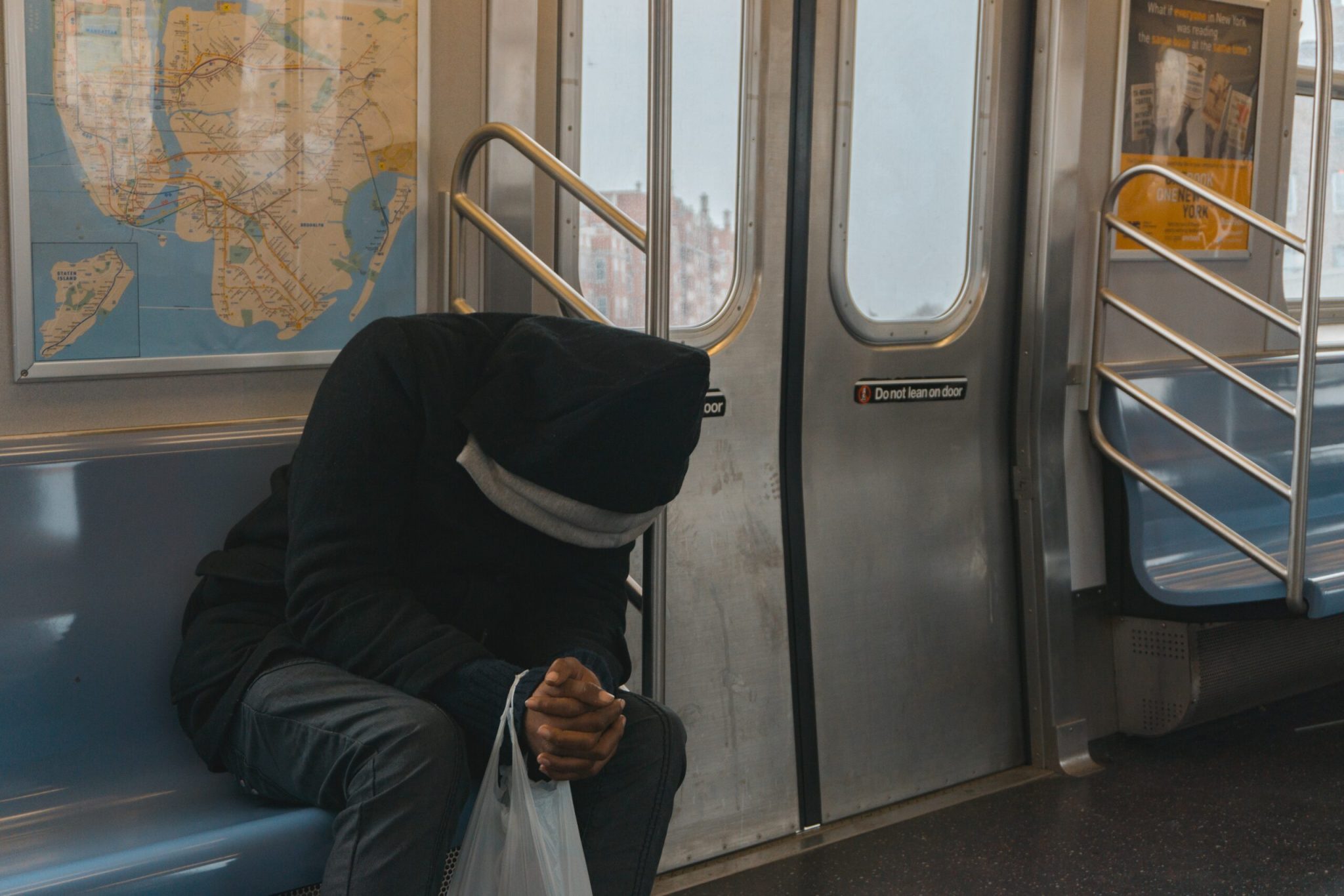 Melanoma Man holding head in hands on train