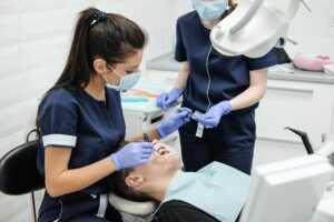 will insurance cover dental implants - person at dentist | Healthier Me Today