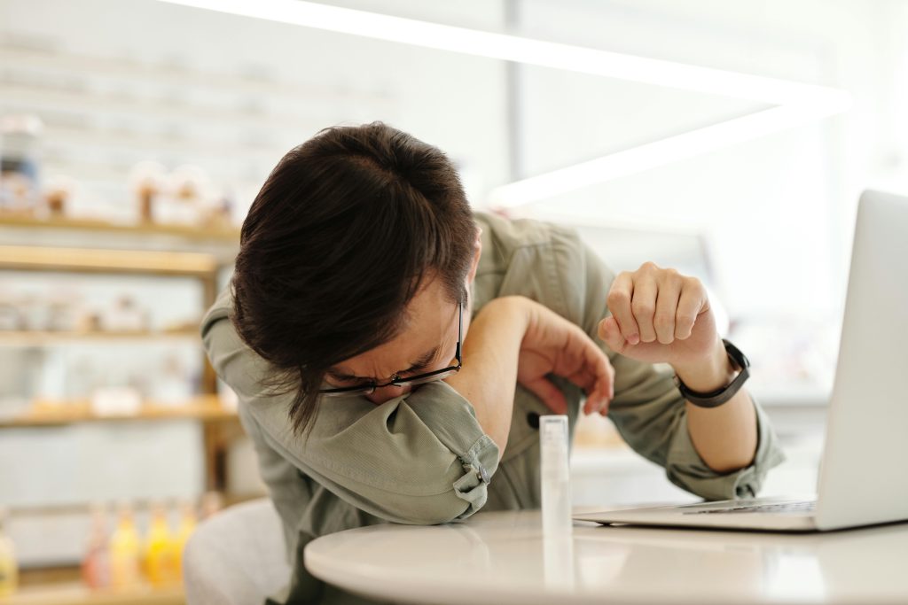 covid 19 cough // man coughing into arm // dark hair
