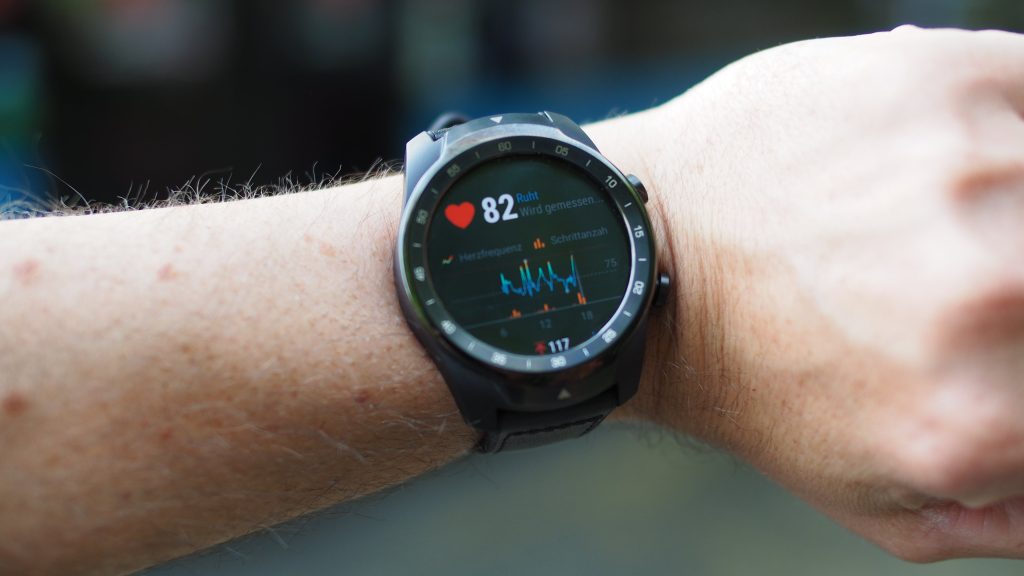 man's arm, watch, displaying heart rate, blurred background // Healthier Me Today