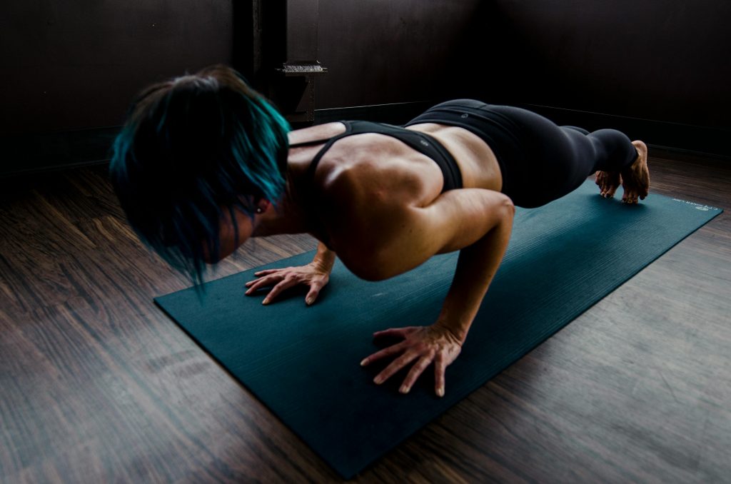 Fat Loss Extreme woman exercising, yoga mat, wooden floor, dark room // Healthier Me Today 