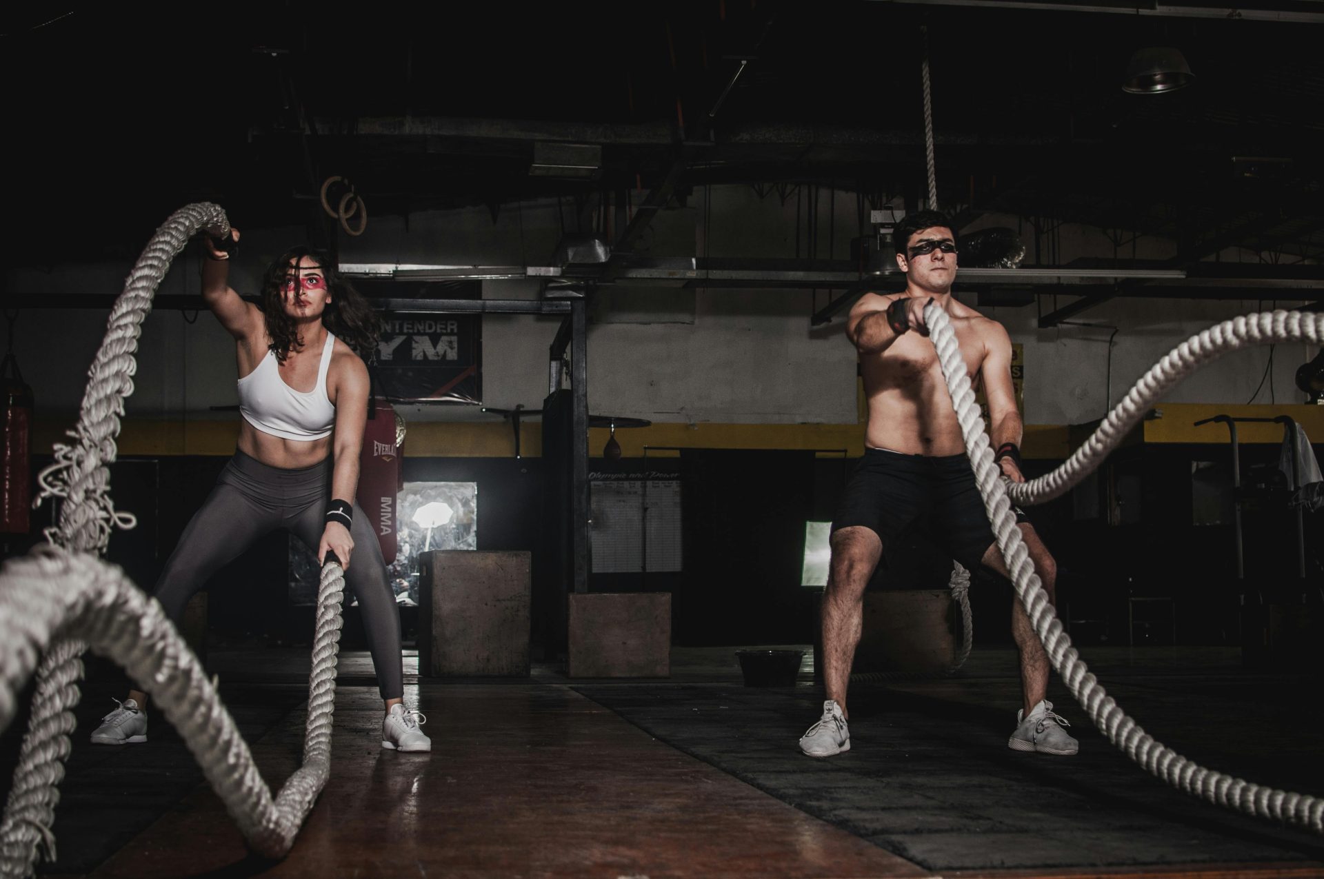 man and woman, wearing glasses, exercising, big ropes, 2 ropes each, dark room, wooden floor // Healthier Me Today