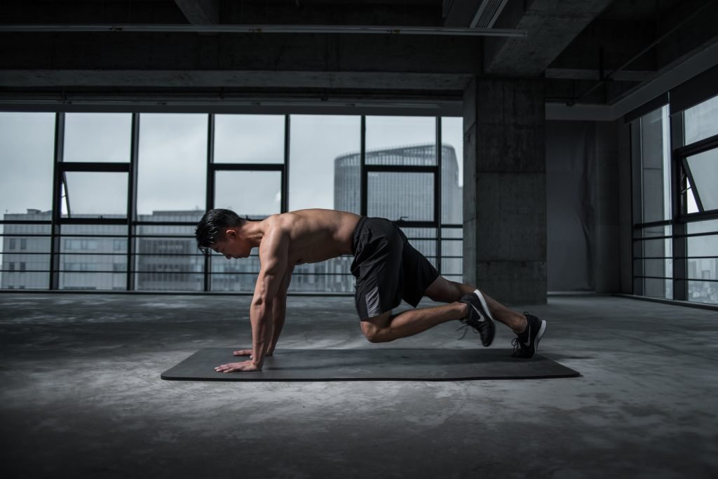 man working out, shirtless, black pants, black workout mat, dark room, big windows, light outside // Healthier Me Today