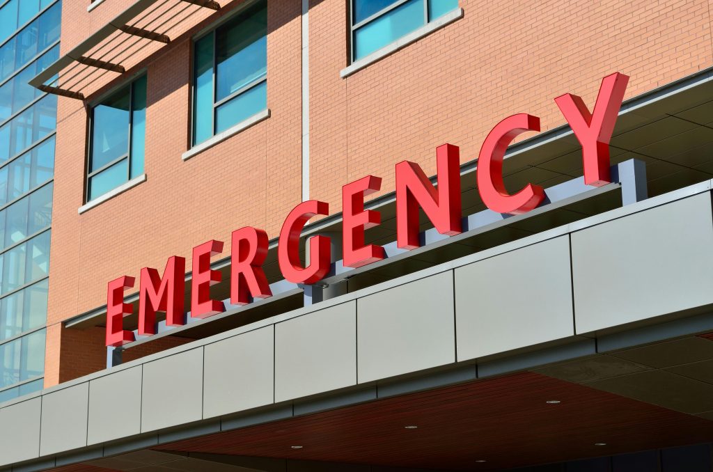 emergency red sign, on building, brick building, many windows // Healthier Me Today