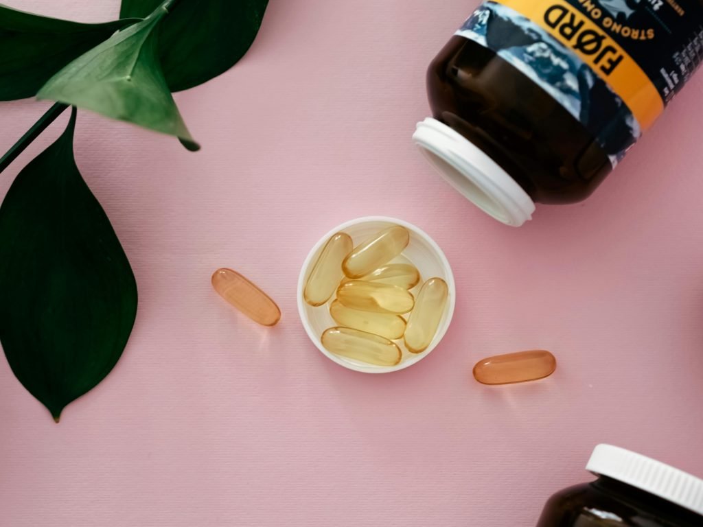 Vial and Pills of Cod-liver Oil on Pink Background // Healthier Pets Today